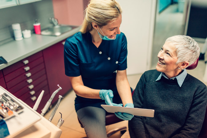 woman at dentist appointment viewing xrays with dentist